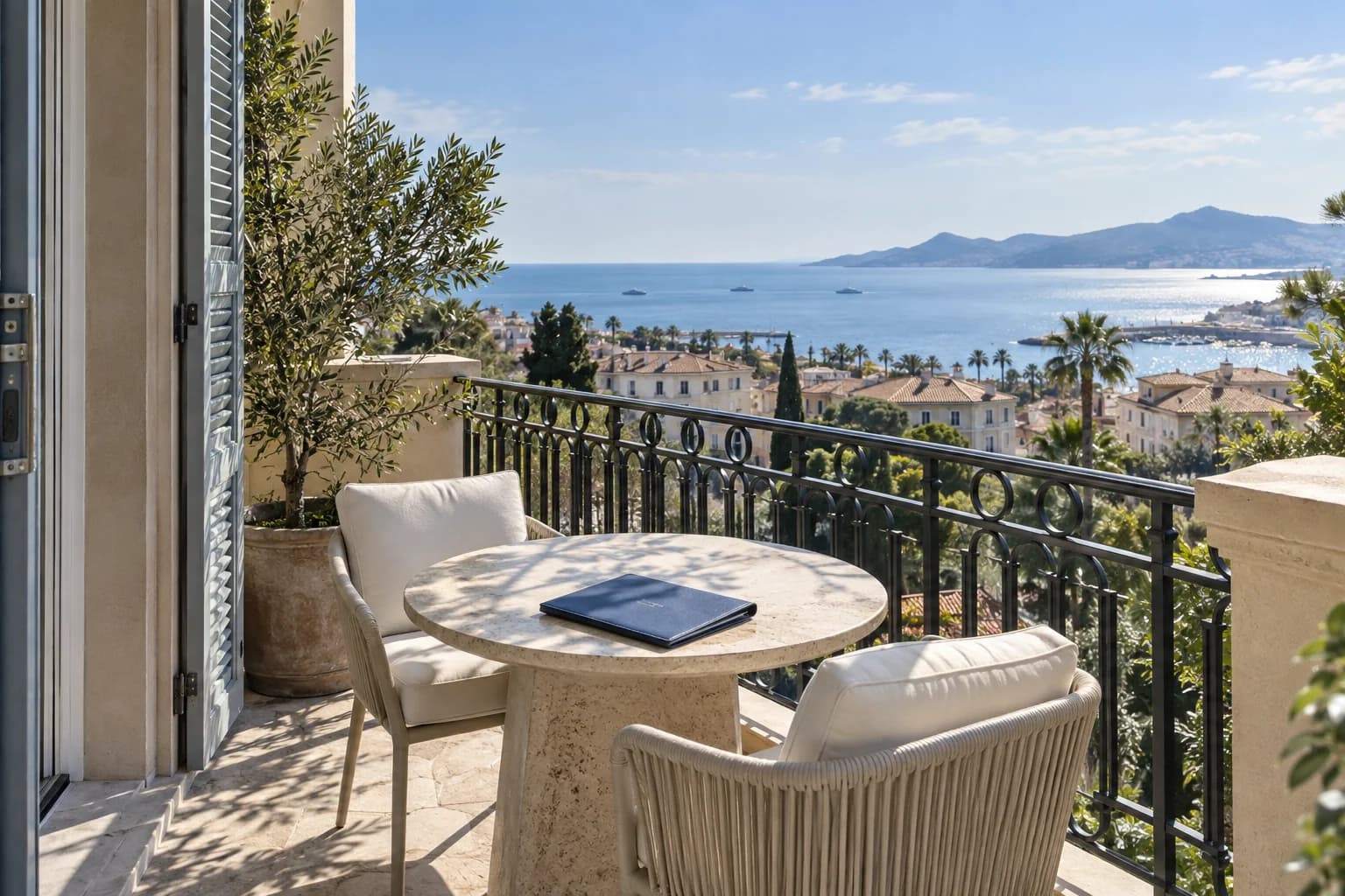 A document folio on a Cannes apartment balcony overlooking the Mediterranean.